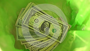 Throwing money away, dollars Fall in green Trash Can basket, freedom from finance, wasting money