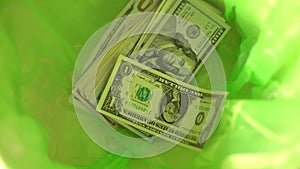 Throwing money away, dollars Fall in green Trash Can basket, freedom from finance, wasting money