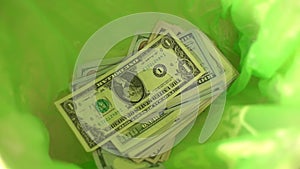 Throwing money away, dollars Fall in green Trash Can basket, freedom from finance, wasting money