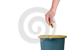 Throwing old used batteries in trash, on white background