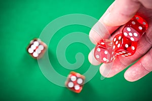 Throwing red poker dices on casino green table