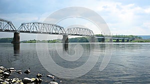 Throwing stones into the river on the background of the bridg