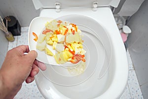 Throwing wasted food into a toilet
