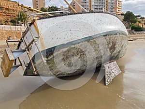 Thrown ashore yacht. Sailing boat on the sandy shore