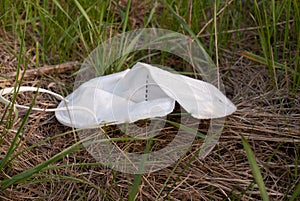 Thrown away FFP2 mask, lies on the roadside in the grass