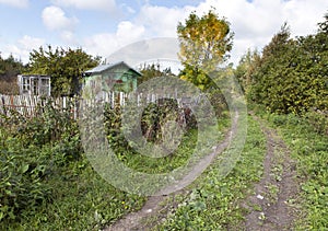 The thrown wooden house and dirt road in rural areas