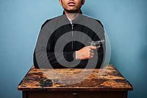 Thug at table with gun