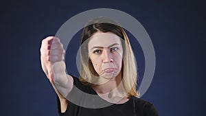 Thumb down beautiful young woman negative expression