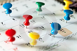 Thumb tack pins on calendar as reminder