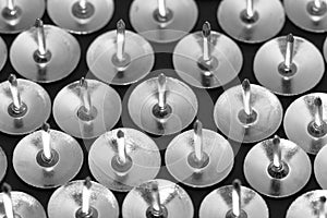 Thumb tacks on a dark background close up. Background