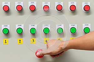 Thumb touch on red emergency stop switch and green start button