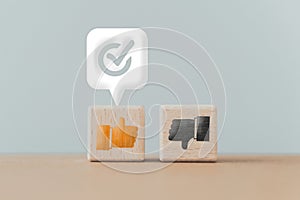 Thumb up ,down icon on wooden cube block with approval sign on white speech bubble , like or dislike , approve or reject,