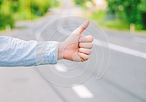 Thumb up gesture try stop car road background. Hand gesture hitchhiking. Make sure you know right gestures to stop car