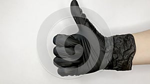 Thumb up hand sign isolated on a white background. Black gloved