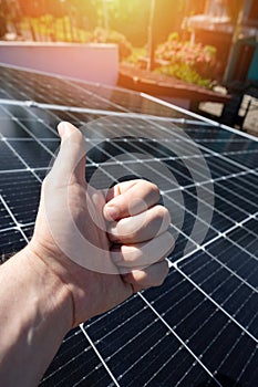 Thumb up on solar panel background