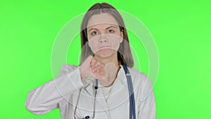 Thumbs Down by Female Doctor on Green Background