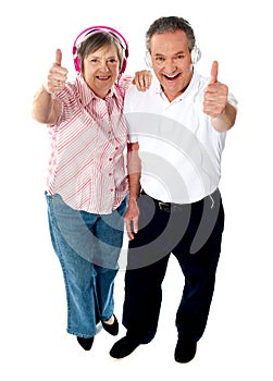 Thumbs-up couple tuned into music