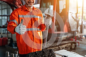 Thumbs up of excavator repair technician with large iron wrench in a hand, Powerful Professional Mechanic. Heavy Duty Equipment