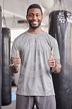 Thumbs up, fitness or black man for wellness portrait, exercise or positive mindset in sport gym. Thank you, support or