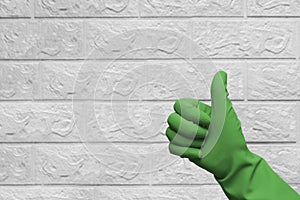 Thumbs up in green protective glove for house cleaning