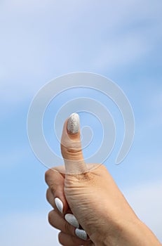 Thumbs up of the hand with the polish on the nails of the girl OK symbol