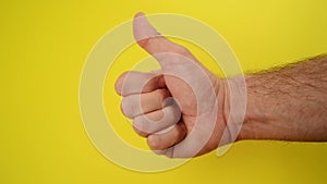 Thumbs Up For Like, male hand endorsing over yellow background