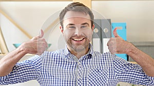 Thumbs Up by Man Sitting in Office photo