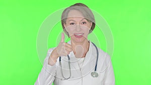 Thumbs Up by Old Female Doctor on Green Background