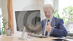 Thumbs Up by Senior Old Businessman while Using Desktop Computer