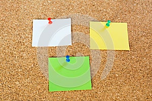 Thumbtack pins and notepaper on pinboard