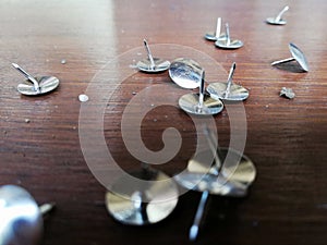 Thumbtack placed on brown wooden background