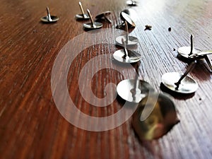 Thumbtack placed on brown wooden background