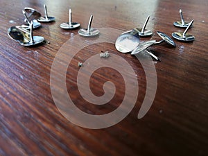 Thumbtack placed on brown wooden background