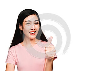 Thums up Happy young beautiful asian woman wearing pink t-shirt isolated on white background photo