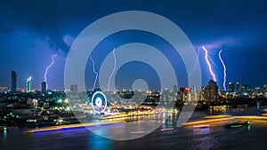 Thunder storm lightning strike on the dark cloudy sky over business building area in Bangkok,Thailand