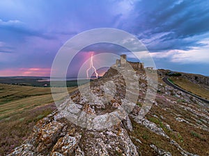 Thunderbolts,lightning on a cloudy evening blue sky over old Enisala stronghold,citadel photo