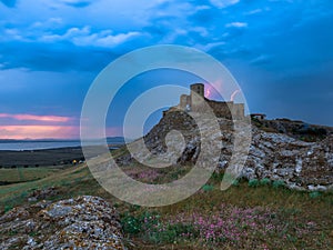 Thunderbolts,lightning on a cloudy evening blue sky over old Enisala stronghold,citadel photo