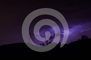 Thunderbolts over the mountains with purple sky