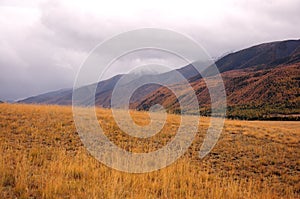 Thunderclouds over a mountain range at the edge of the autumn desert steppe photo