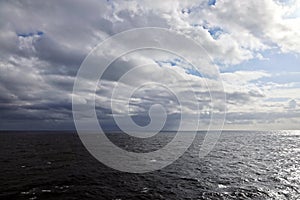 Thunderclouds and rain clouds over the sea horizon and the surface of the Pacific Ocean.