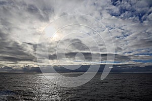 Thunderclouds and rain clouds over the sea horizon and the surface of the Pacific Ocean.