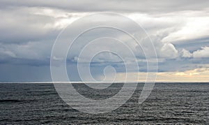 Thunderclouds and rain clouds over the sea horizon and the surface of the Pacific Ocean.