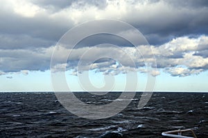 Thunderclouds and rain clouds over the sea horizon and the surface of the Pacific Ocean.