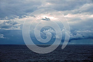 Thunderclouds and rain clouds over the sea horizon and the surface of the Pacific Ocean.