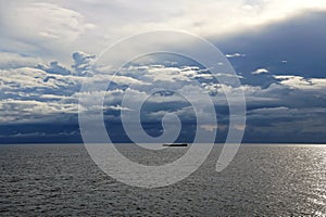 Thunderclouds and rain clouds over the sea horizon and the surface of the Pacific Ocean.