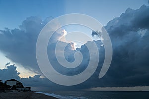 Thunderous gloomy clouds on the sea coast before dawn