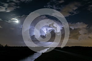 Thunderstorm clouds are illuminated by lightning