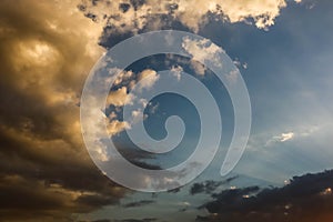 Dramatic darkclouds under blue sky with sunbeam