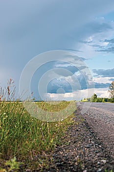 thunderstorm and heavy rain in a field above the road at a beautiful sunset in the summer, the problem of a slippery road