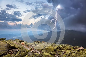 Tormenta encendiendo a nubes en montanas 